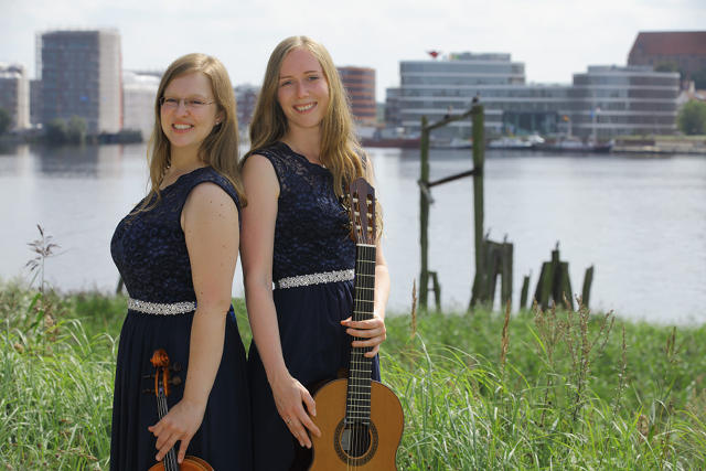 Das Duo posiert vor der Unterwarnow in Rostock